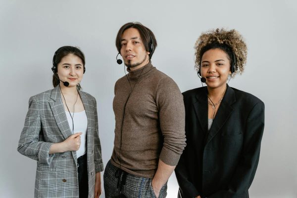 Team of customer service agents wearing headsets providing custom support solutions